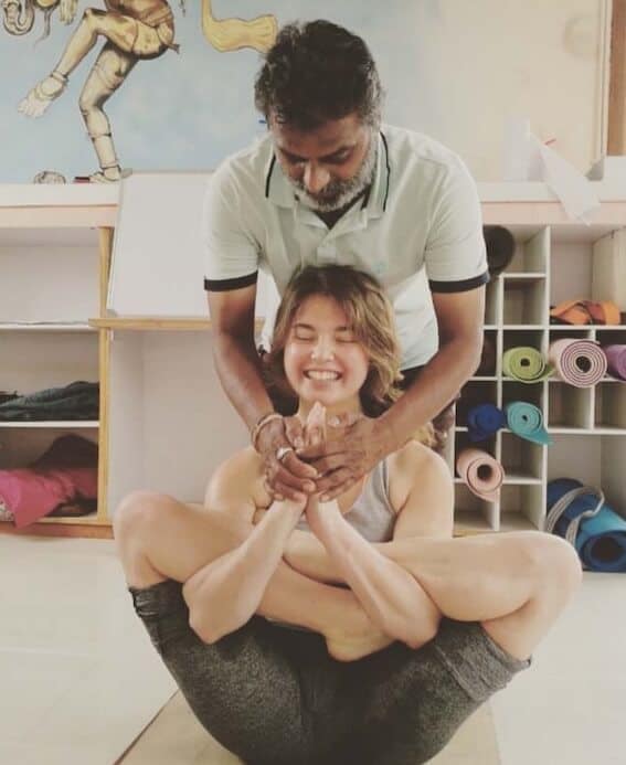 Lisa en posture de yoga, assistée par un professeur