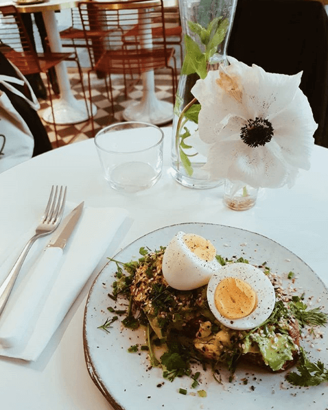 Assiette d’œufs durs et de légumes sur une table de restaurant fleurie