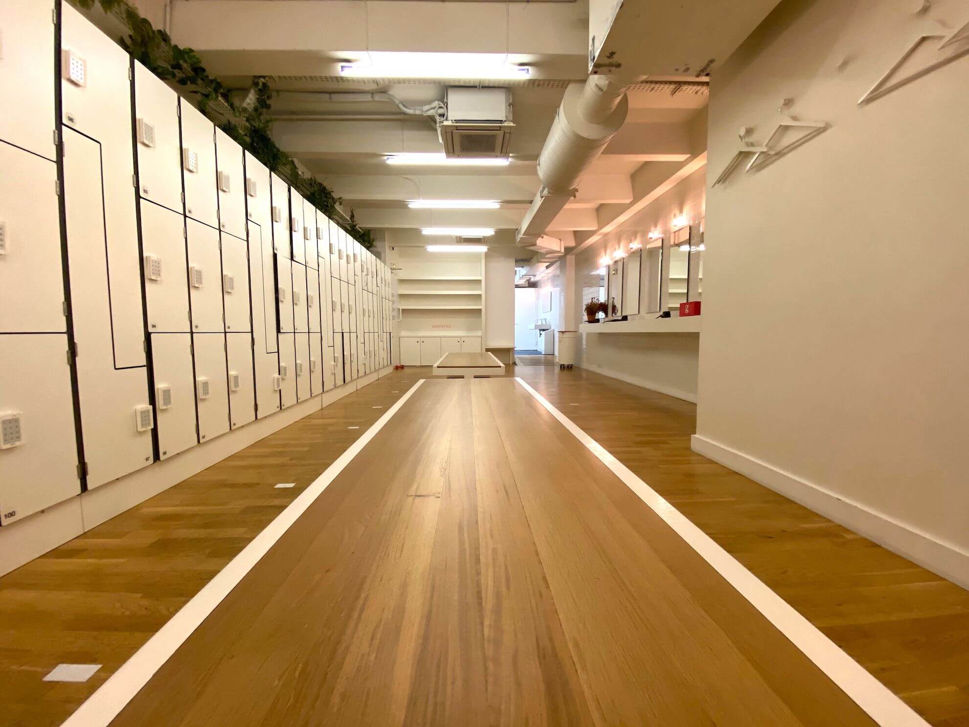 Couloir des vestiaires du studio Boétie, casiers blancs et parquet