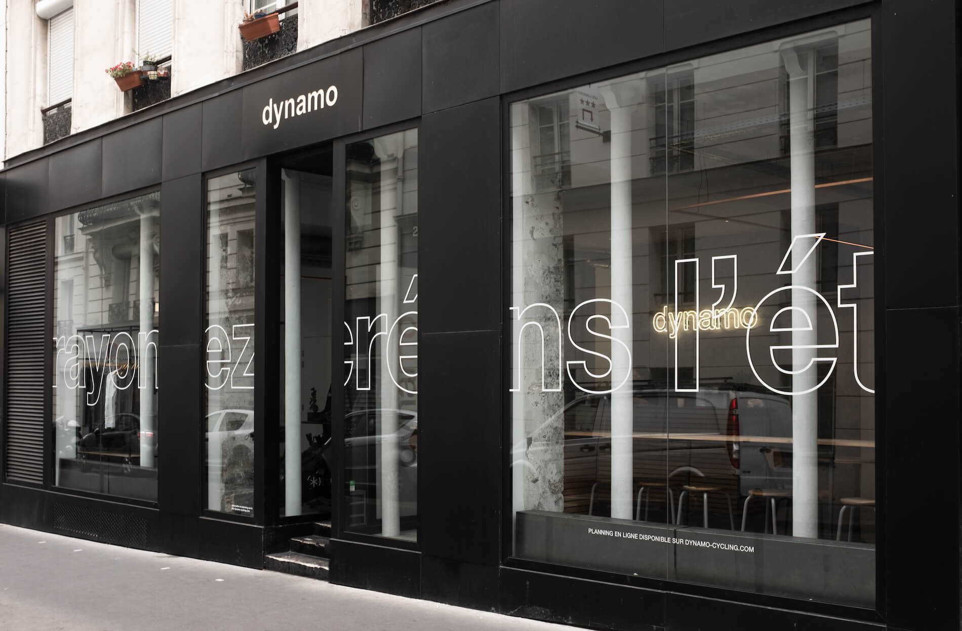 Façade noire vitrée du studio Oberkampf, enseigne dynamo