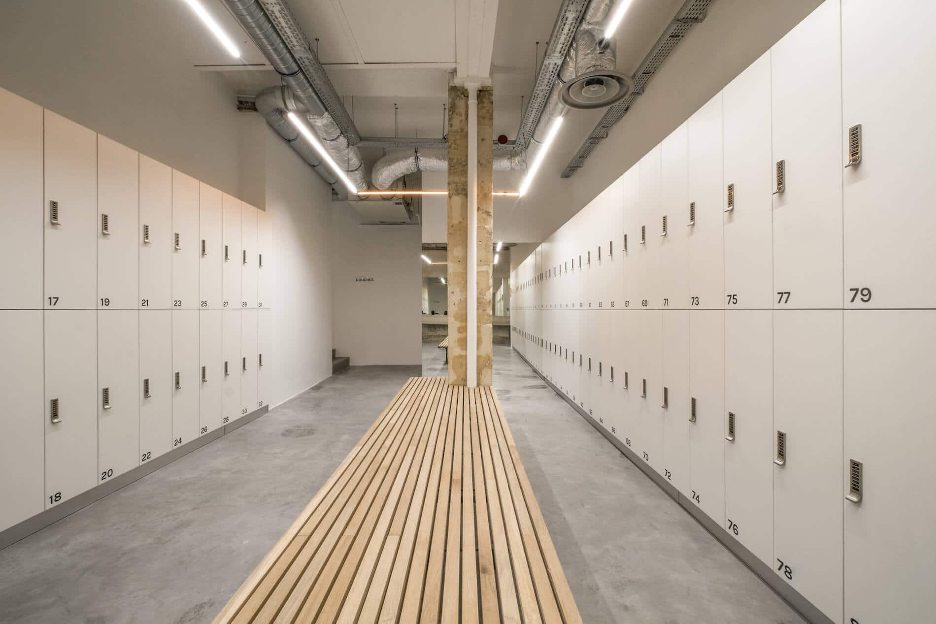 Vestiaires du studio Oberkampf : longue rangée de casiers et banc en bois