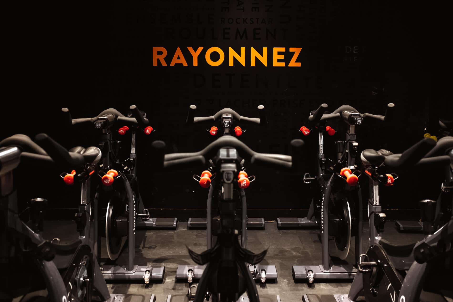 Salle de cycling du studio Opéra : vélos alignés sous l’inscription RAYONNEZ