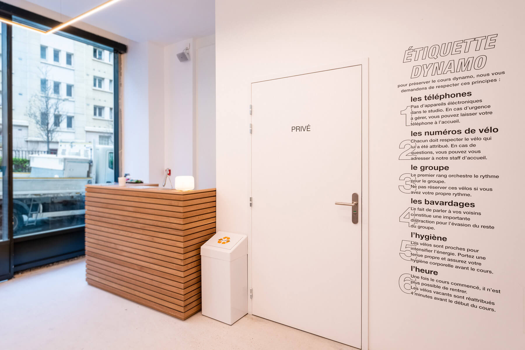 Accueil du studio Sèvres, comptoir en bois et texte « Étiquette dynamo » au mur